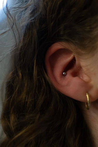 Gyógyult Conch (belső fülporc) piercing egyszerű titán golyós ékszerrel, Soospierce precíz szúrása.